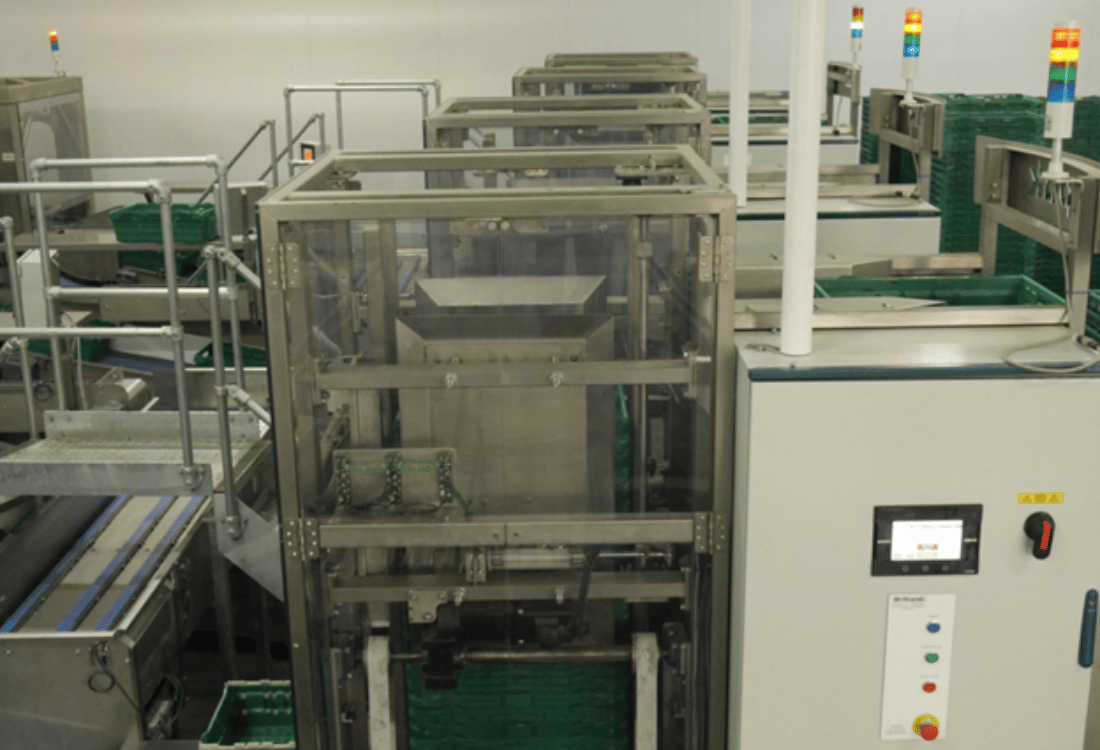 Automatic crate destacker in operation, efficiently separating stacked crates in a packhouse environment.