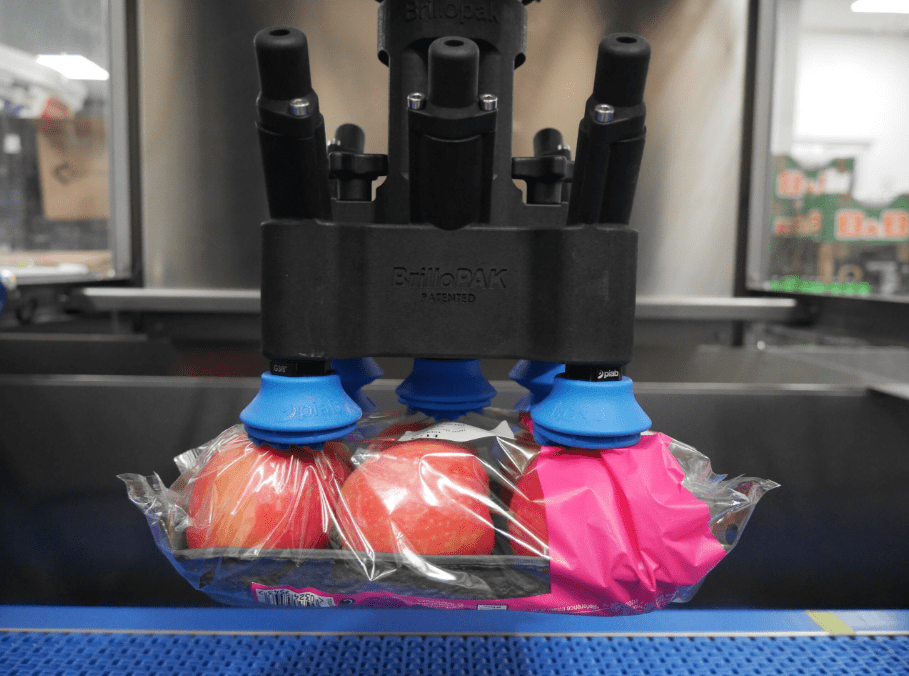 A suction cup end effector efficiently picking up apples during the food packing process.